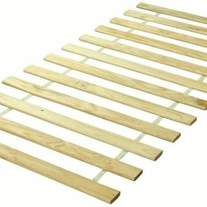 May include: A wooden bed slat frame with multiple parallel wooden slats, connected by thin, light-colored supports. The slats are a light brown color and are arranged in a rectangular shape.