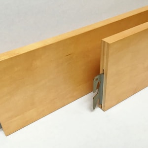 May include: Two wooden bed slats with metal brackets. The slats are light brown and the brackets are silver.