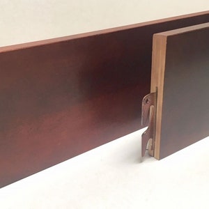 May include: Two wooden bed rails with metal brackets. The rails are a dark reddish-brown color.
