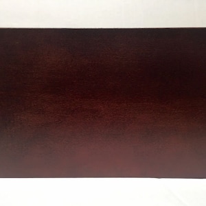 May include: A close-up of a dark brown wooden surface. The surface has a smooth, polished finish.