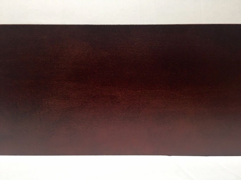 May include: A close-up of a dark brown wooden surface. The surface has a smooth, polished finish.