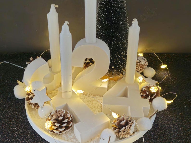 K&ouml;nnte beinhalten: Wei&szlig;er Holz-Adventskalender mit vier Kerzen, einem kleinen Tannenbaum und wei&szlig;en Lichtern. Die Zahlen 1, 2, 3 und 4 sind auf dem Kalender abgebildet.