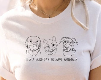 Könnte beinhalten: Weißes T-Shirt mit einer Strichzeichnung von drei Tiergesichtern: einem Hund, einer Katze und einem Hund. Der Text "It's a good day to save animals" ist unter den Zeichnungen gedruckt.