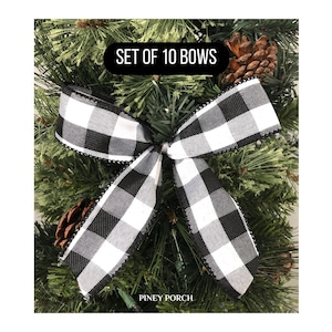 May include: Set of 10 black and white buffalo plaid bows. The bows are tied with a black ribbon and have a white and black checkered pattern.