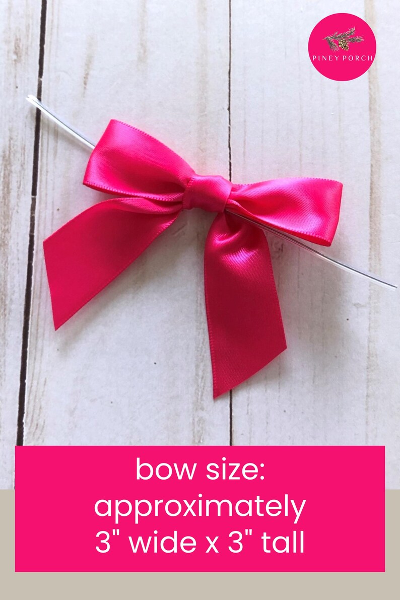 Pode incluir: Um la&ccedil;o de fita de cetim rosa choque com um n&oacute; central e duas pontas voltadas para baixo. Um fio de pl&aacute;stico fino e transparente atravessa horizontalmente o centro do la&ccedil;o. O texto na imagem diz: bow size: approximately 3" wide x 3" tall.