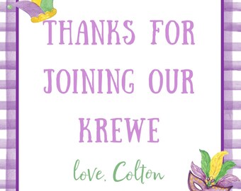 May include: Purple and white gingham background with a white square in the center. The square has the text "THANKS FOR JOINING OUR KREWE love. Colton" in purple. A purple, green, and yellow jester's hat is in the top left corner and a purple, green, and yellow masquerade mask is in the bottom right corner.