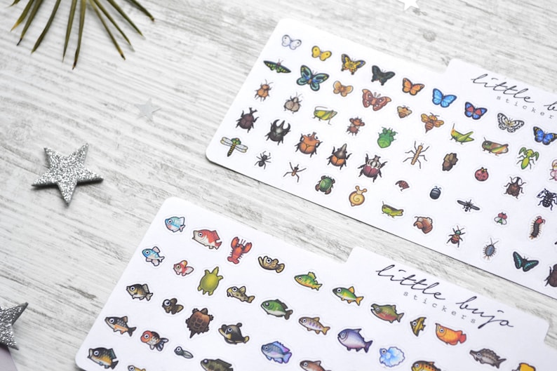 May include: Two sheets of stickers featuring illustrations of insects and fish. The insect sheet has a variety of colourful butterflies, beetles, and other bugs. The fish sheet has a variety of colourful fish, turtles, and a lobster. Both sheets have the text "little bujo stickers" printed on them.
