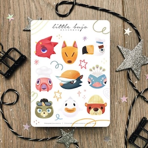 Puede incluir: Una hoja de pegatinas con caras de animales de dibujos animados de colores. Las pegatinas incluyen un dragón rojo, un zorro, un pájaro, un chef, un lobo, un pavo real, un oso, un pato y un castor. El texto "little bujo stickers" está en la parte superior.