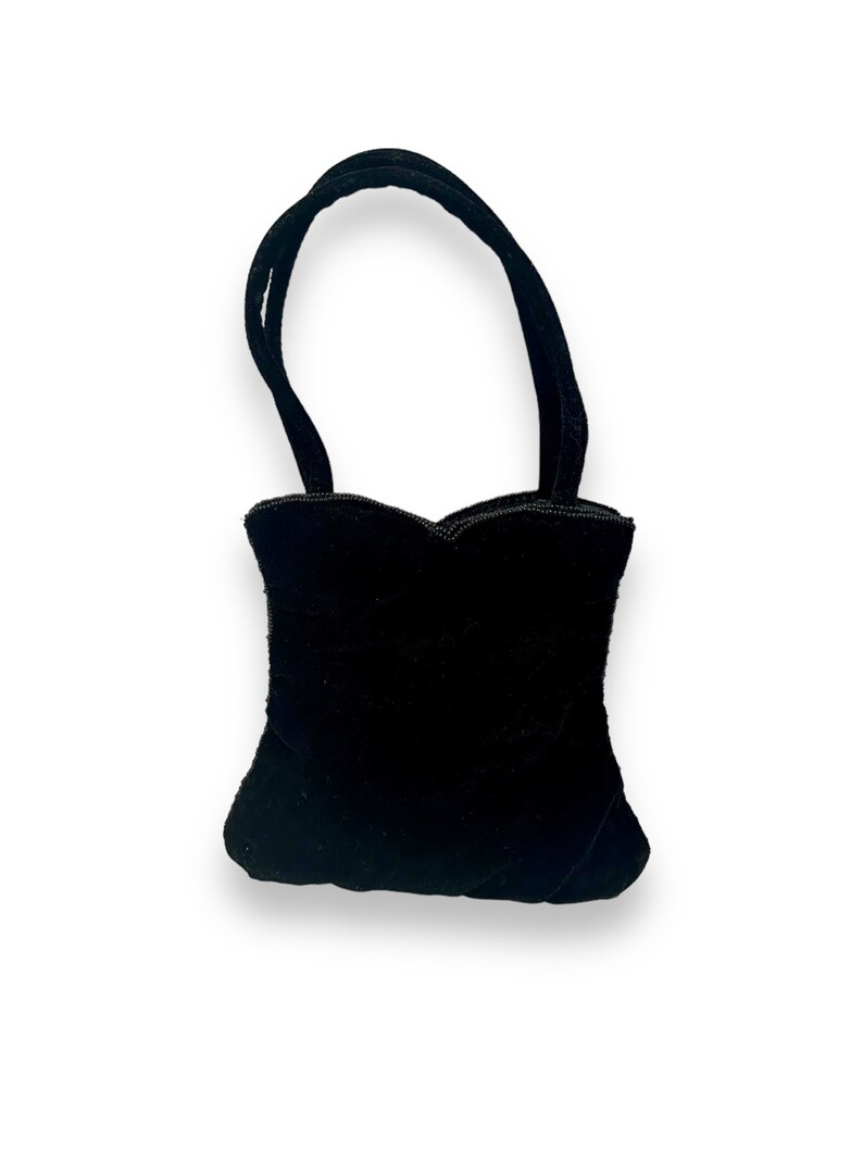May include: A small black velvet handbag with a heart-shaped design and a single top handle.