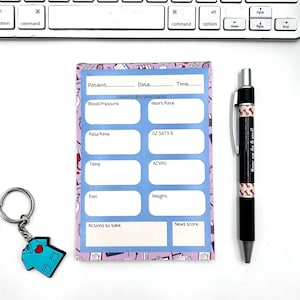 May include: A medical-themed stationery set including a notepad, pen, and keychain. The notepad has a blue border and sections for patient details. The pen is black with a patterned design and the text "Never say the O word!". A blue scrubs keychain is also included.