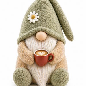 Pode incluir: Uma boneca de gnomo de pelúcia com um chapéu verde adornado com uma margarida branca. O gnomo tem uma longa barba branca, um nariz de madeira e segura uma pequena caneca vermelha de café com arte latte. O corpo do gnomo é bege e verde.