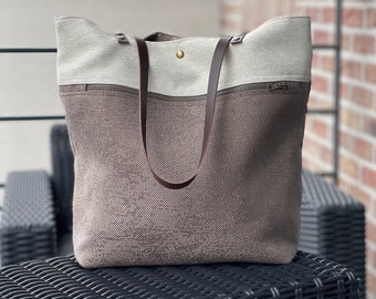 Large tote bag with interior and exterior zipper closes with a magnetic clasp.
