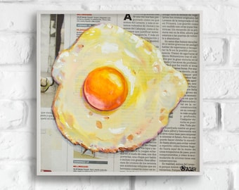 May include: A painting of a fried egg on a newspaper background. The egg is yellow with a bright orange yolk and a white background. The newspaper text is blurry.