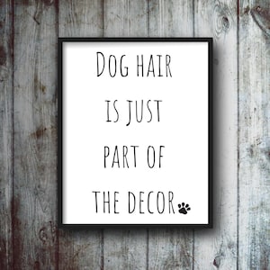 May include: Black framed print with a white background and black text that reads "Dog hair is just part of the decor" with a paw print icon.