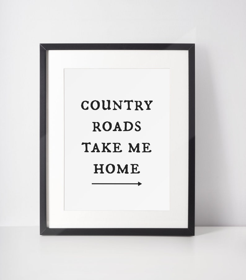 May include: Black framed print with the text "COUNTRY ROADS TAKE ME HOME" and an arrow pointing to the right.