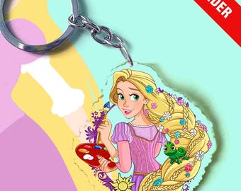 May include: A circular acrylic keychain featuring a cartoon illustration of a blonde character with long braided hair decorated with flowers, holding a paintbrush and palette, with a small green lizard, attached to a silver metal split ring.