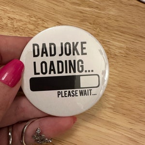 以下が含まれることがあります： 「Dad Joke Loading...」という黒い文字が書かれた白いボタン。ほぼ満タンのプログレスバーが表示されています。「Please Wait...」という文字がプログレスバーの下にあります。