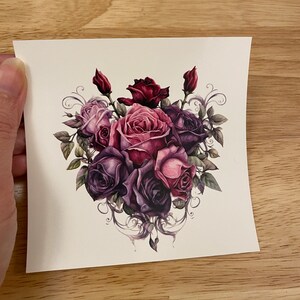 May include: A temporary tattoo featuring a bouquet of purple, pink, and burgundy roses with intricate floral details.