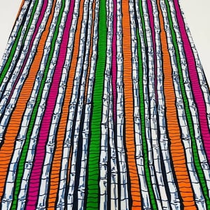 May include: A colorful fabric with a repeating pattern of vertical white bamboo stalks on a black background. The bamboo stalks are outlined in orange, green, and pink.