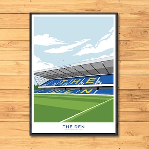 Peut inclure: Une affiche encadrée représentant un stade de football avec des sièges bleus et un terrain vert. Le texte "THE DEN" est en bas, avec "COLD BLOW LANE" au-dessus des gradins. Le ciel est bleu clair avec des nuages blancs.