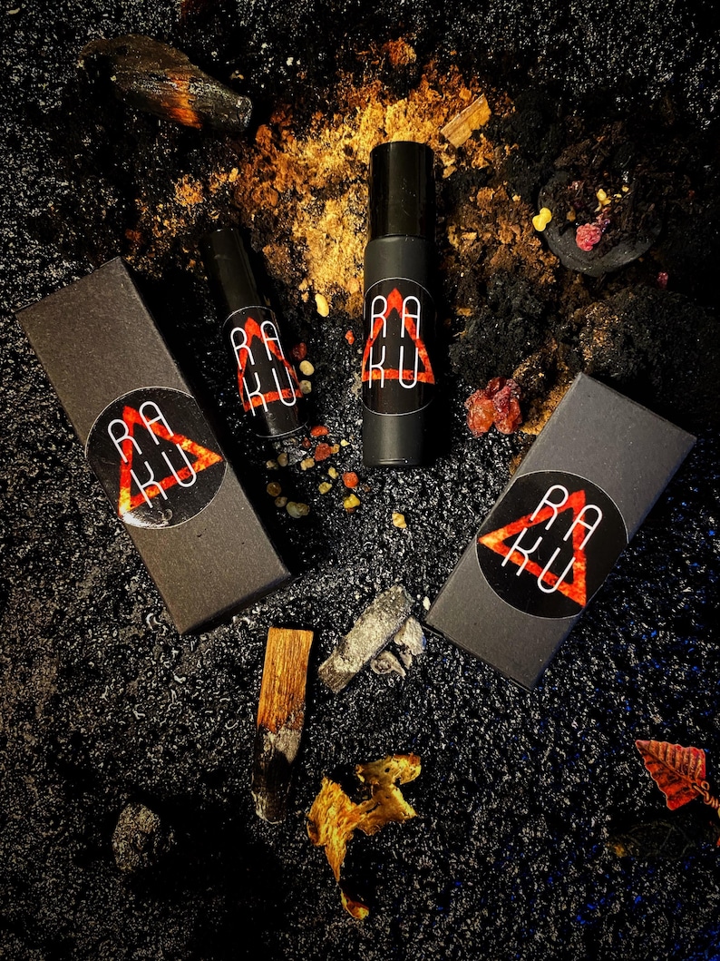 May include: Three black boxes with a red triangle and the text "RAKU" in white. The boxes are on a black surface with gold and red accents.