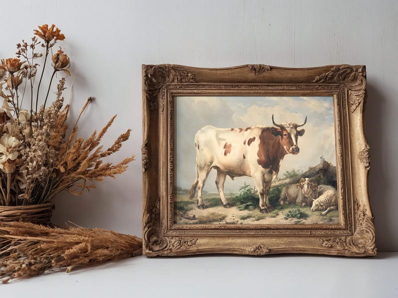 A framed painting of a cow and sheep in a pastoral setting with a cloudy sky. Beside it, dried flowers and grasses in a rustic vase on a wooden surface.