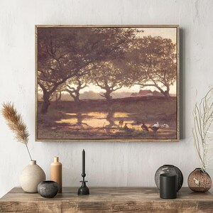 A rustic landscape painting with trees and ducks is mounted above a wooden shelf. The shelf holds vases, a candle, and dried plants, creating a serene and cozy atmosphere.
