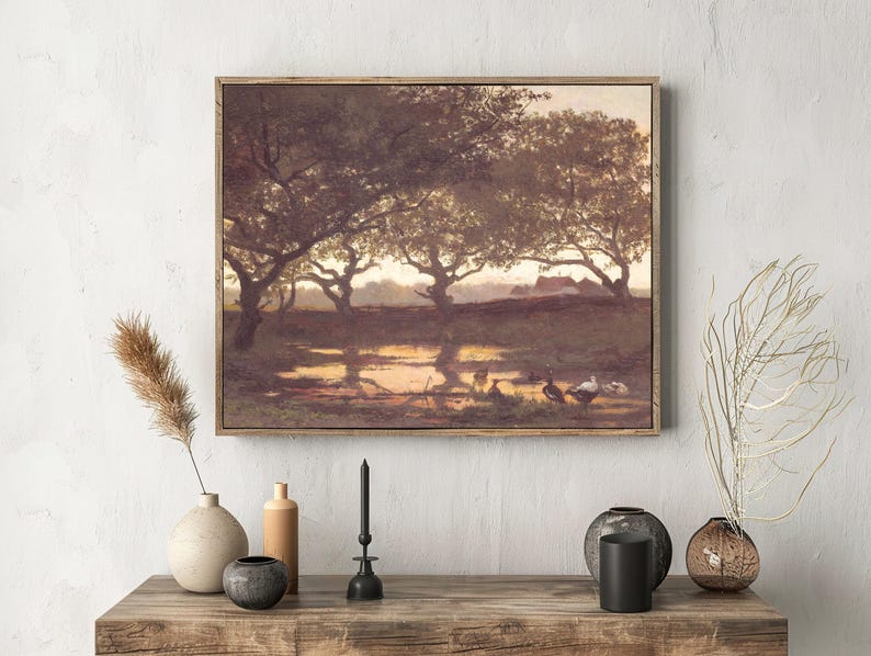 A rustic landscape painting with trees and ducks is mounted above a wooden shelf. The shelf holds vases, a candle, and dried plants, creating a serene and cozy atmosphere.