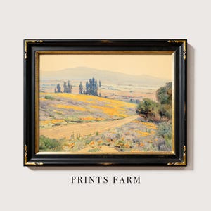 Framed landscape painting with rolling fields and distant mountains. Yellow flowers and trees under a soft sky. Text below reads "Prints Farm."