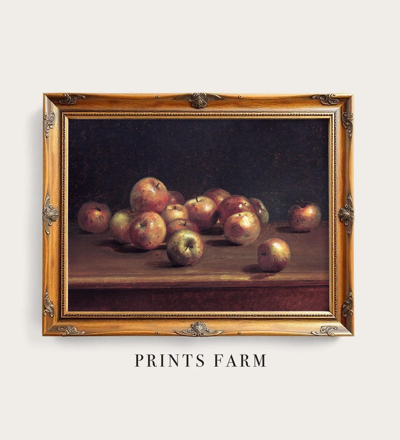 A classic still-life painting shows apples on a wooden table, richly depicted in warm tones. The ornate wooden frame adds elegance. "Prints Farm" text below.