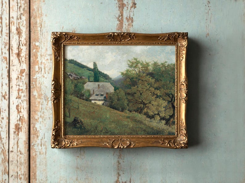 Framed landscape painting on a textured wall depicts a serene countryside with a cottage, lush green hills, and a large tree, evoking tranquility.