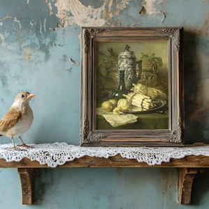 A small bird stands on a lace-covered wooden shelf beside a framed still-life painting. The background has a weathered, textured blue wall, evoking a vintage feel.