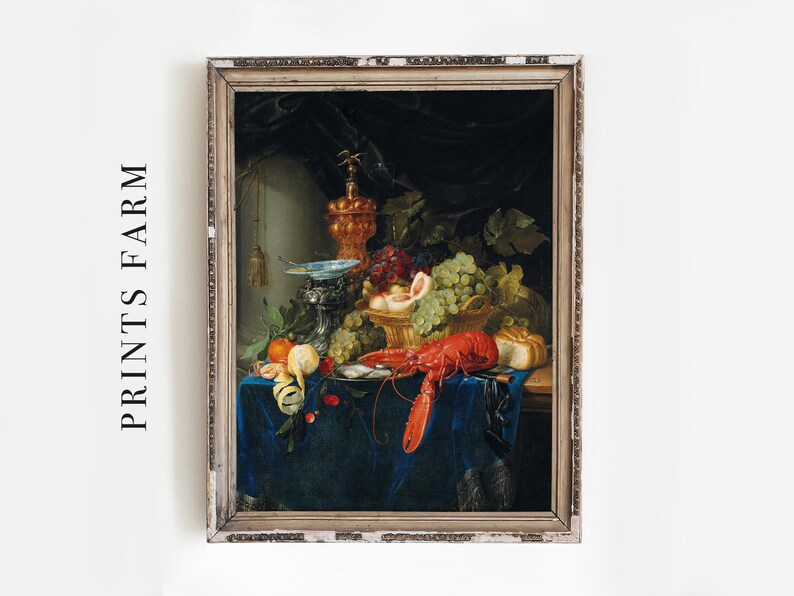 The image shows a classical still life painting featuring an arrangement of various fruits, a lobster, and decorative objects on a dark blue cloth-covered table, set against a dark background with draped fabric. The frame of the painting is ornate and weathered, adding an antique touch. The composition emphasizes richness and abundance, with grapes, peaches, and other fruits prominently displayed.