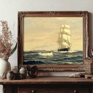 The scene is a cozy, vintage-inspired still life with a framed painting of a sailing ship, dried branches and a green leaf in a vase, dried flowers and brushes in a basket, and various decorative items like shells, glasses, and a box on a wooden surface.