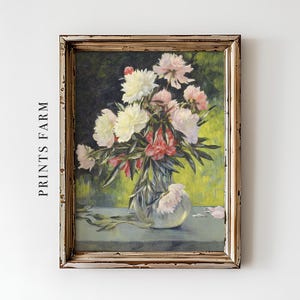 A framed painting of a floral arrangement with white and pink flowers in a vase, set against a greenish background. The frame is rustic and weathered.