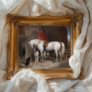 Framed painting of a white horse with two dogs, set in a stable. The frame is ornate, surrounded by billowing white fabric, conveying elegance.