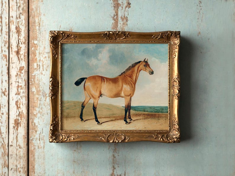 A framed painting of a horse standing in a field is mounted on a textured, weathered blue wall. The ornate golden frame adds classic elegance.