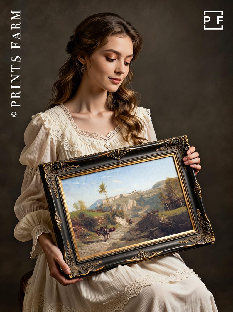 A woman in a white lace dress holds an ornate-framed landscape painting featuring mountains and a winding path. She gazes at it with a serene expression.