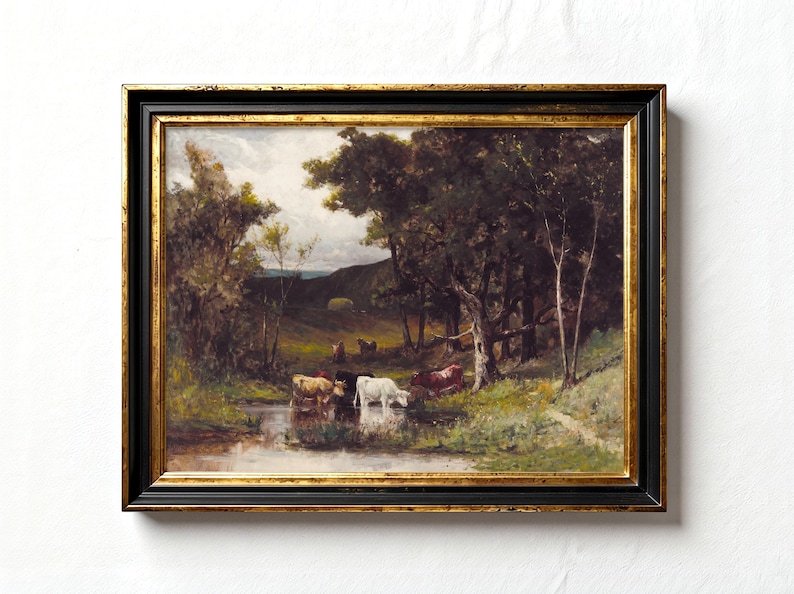 Framed painting of a serene landscape with a small herd of cows drinking from a stream, surrounded by trees and lush greenery under a cloudy sky.