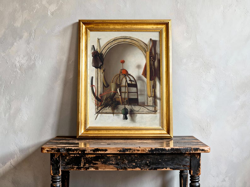 A framed painting with a gold border depicts a whimsical still life with a cage, various tools, and objects against an arched backdrop, resting on a rustic wooden table. The scene feels nostalgic and surreal.