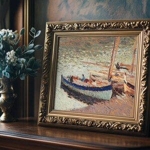 A framed impressionist painting of boats on water, richly textured with soft brushstrokes. Beside it is a vase of white flowers on a wooden table.