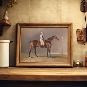 A framed painting of a jockey on a horse is resting on a wooden shelf in a rustic kitchen. Nearby, jars hold spices and vibrant orange tomatoes.