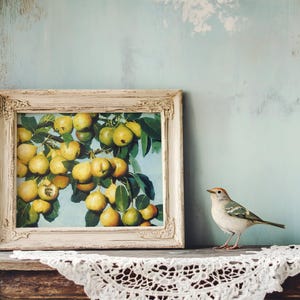 A rustic wooden shelf with a lace cloth holds a framed painting of pears. Beside it, a small bird perches, creating a serene, vintage atmosphere.