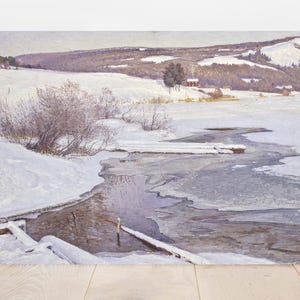 Snowy landscape painting featuring a partially frozen river, bare trees, and distant hills. A small house and muted tones convey a serene, chilly atmosphere.