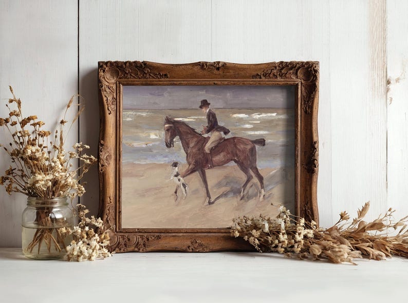 Framed painting of a horseback rider and dog on a beach, with gentle waves in the background. Surrounded by dried flowers, conveying a nostalgic and serene ambiance.