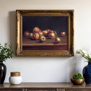 A classic still-life painting of apples in a gold frame hangs above a wooden console. Vases with greenery and white flowers adorn the console, creating a serene ambiance.