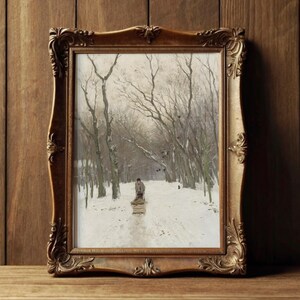 Framed painting of a snowy path through leafless trees, with a person pulling a sled. The scene conveys a serene, wintery atmosphere.