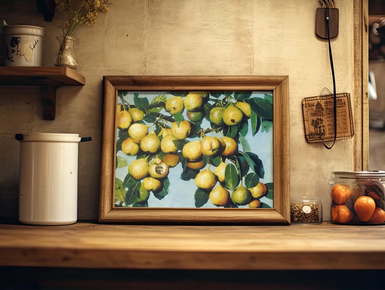 Framed painting of pears on a branch sits on a wooden shelf. Nearby are jars and kitchen items, creating a warm, rustic kitchen atmosphere.