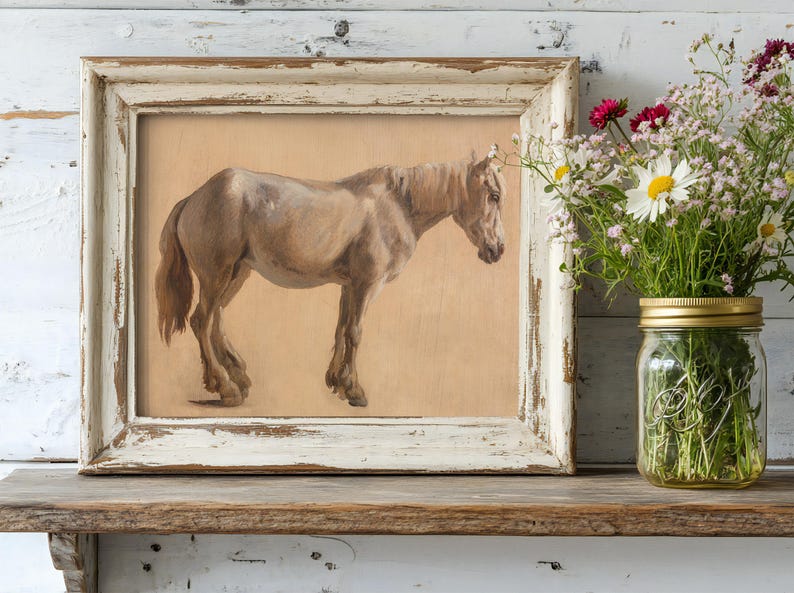 A rustic painting of a brown horse in a weathered frame sits on a wooden shelf. Beside it, a mason jar holds vibrant wildflowers, creating a cozy, vintage feel.