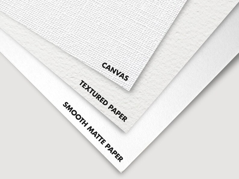 Close-up of three different types of paper and canvas: smooth matte paper, textured paper, and canvas. The text "CANVAS", "TEXTURED PAPER", and "SMOOTH MATTE PAPER" is printed on each surface.
